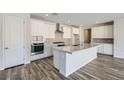 Modern kitchen features white cabinets, stainless appliances, and a large center island at 8401 Waterwood St, Las Vegas, NV 89166