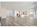 Open-concept living space with hardwood floors, flowing into kitchen with white cabinets at 8401 Waterwood St, Las Vegas, NV 89166