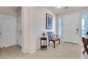 Bright foyer features tiled flooring, a decorative bench, and a view of the front door and nearby access doors at 10105 Shore Pine Ave, Las Vegas, NV 89129