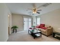 Cozy living room featuring a beige sofa, coffee table, and access to a patio at 4750 Newby Hall Ct, Las Vegas, NV 89130