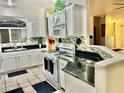 Bright kitchen features white cabinets, sleek black countertops, and stainless-steel appliances at 8721 Red Brook Dr # 203, Las Vegas, NV 89128