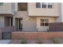 Townhome with gray siding, blue door, and a brick paved patio at 659 Spotted Falcon St, Las Vegas, NV 89138