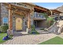 Inviting home featuring a charming stone facade, pergola-covered entrance, and beautiful wooden door at 868 Marina Dr, Boulder City, NV 89005