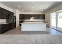Modern kitchen with a large island, stainless steel appliances, and dark wood cabinets at 10208 Bismarck Palms Ave, Las Vegas, NV 89166