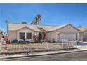 Inviting single-story home boasting desert landscaping, a white picket fence, and a well-maintained front yard at 4357 Valley Regal Way, North Las Vegas, NV 89032