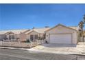 Well-maintained single-story house with a two-car garage, desert landscaping, and a charming white picket fence at 4357 Valley Regal Way, North Las Vegas, NV 89032