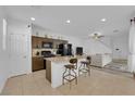 Bright, open floor plan featuring a kitchen island, modern cabinetry and appliances, and view of the living area at 734 Last Dance Pl, Henderson, NV 89011
