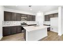 Modern kitchen boasts stainless steel appliances, white countertops, and an island with a sink and breakfast bar at 655 N Water St, Henderson, NV 89015