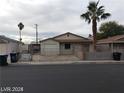 Inviting single-story home featuring a secure gated front yard and mature palm trees offering shade and curb appeal at 1929 Evelyn Ave, Henderson, NV 89011
