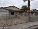 Single-story home with metal gated courtyard and covered entry, offering privacy and a secure outdoor space at 1929 Evelyn Ave, Henderson, NV 89011