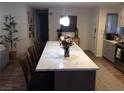Kitchen island with chairs, quartz counters, pendant lights, and views of the open-concept floor plan at 3909 Woodhill Ave, Las Vegas, NV 89121
