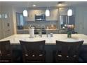 Bright kitchen featuring an island with quartz countertops and modern pendant lighting at 3909 Woodhill Ave, Las Vegas, NV 89121