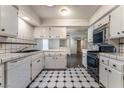 Galley kitchen featuring white cabinetry, tile countertops, and black and white tile flooring at 3125 Pinehurst Dr # A, Las Vegas, NV 89109