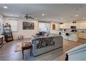 Inviting living room featuring an open layout, wood-look tile flooring, and access to the kitchen at 11273 Hidden Peak Ave # 101, Las Vegas, NV 89135