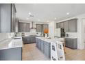 Spacious eat-in kitchen featuring gray cabinets, stainless steel appliances, and a center island at 10172 Magnolia Creek St, Las Vegas, NV 89141