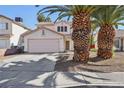 Two-story house with pink garage door and palm trees in front at 1712 Orchard Valley Dr, Las Vegas, NV 89142