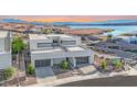 Contemporary home boasts clean lines, a flat roof, and an attached garage, nestled in a lakeside community at 28 Rainbow Point Pl, Henderson, NV 89011