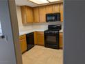 A bright kitchen features wood cabinets and black appliances at 331 Seine Way # 331, Henderson, NV 89014