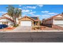 Two-story house with a tan exterior, solar panels, and a white garage door at 6370 Canyon Vista Ct, Las Vegas, NV 89156