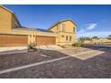 Side view of two story townhome showing three garage doors and low maintenance landscaping at 1065 Admiral Emblem St, Henderson, NV 89015