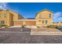 Pair of two-car garages with adjacent townhomes, solar panels, and paved driveway at 1065 Admiral Emblem St, Henderson, NV 89015