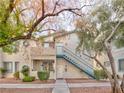 Two-story building exterior with blue stairs and landscaping at 4960 Harrison Dr # 214, Las Vegas, NV 89120