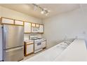 Efficient kitchen design featuring stainless steel refrigerator, white appliances, and ample counter space at 4960 Harrison Dr # 214, Las Vegas, NV 89120