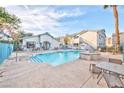 Community pool with lounge chairs and tables for relaxing poolside at 4960 Harrison Dr # 214, Las Vegas, NV 89120