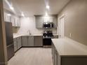 Modern kitchen with gray cabinets, stainless steel appliances, and white countertops at 2678 Aracatuba Ave, Las Vegas, NV 89121