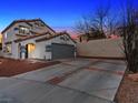Evening view of two-story house with attached garage at 2801 Willow Wind Ct, Las Vegas, NV 89117
