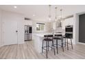 Well-lit kitchen with white cabinets, stainless steel appliances, a large island, and sleek countertops at 10631 Sariah Skye Ave, Las Vegas, NV 89166