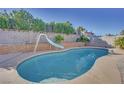 Inviting kidney-shaped pool with a slide in the backyard at 512 Purcell Dr, Las Vegas, NV 89107