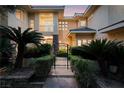 Elegant home exterior with a gated entrance, mature palm trees, and manicured landscaping at 605 Canyon Greens Dr, Las Vegas, NV 89144