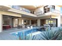 Luxury backyard with a modern pool, fire pit, and multiple seating areas under a covered patio with an adjacent wine room at 4 Olympia Summit Dr, Las Vegas, NV 89141