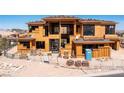 Front view of a new home under construction with framing, roof tile installation, and temporary construction materials onsite at 4 Olympia Summit Dr, Las Vegas, NV 89141