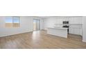 Bright, open-concept with wood floors, a white kitchen, an island, and sliding glass doors at 651 N Water St, Henderson, NV 89015