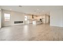 Open-concept living area with wood-look tile floors, fireplace, and bright kitchen in the background at 853 Bittern Lake St, Henderson, NV 89011
