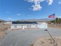 House exterior showcasing solar panels, a two-car garage, and an American flag at 2360 Greyhound St, Pahrump, NV 89060