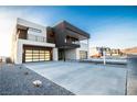 Modern two-story home with a sleek design, two-car garage, and a spacious driveway and desert landscaping at 3690 S Spring Mountain Blvd, Pahrump, NV 89048
