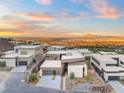 Bird's-eye view of contemporary homes nestled in a neighborhood with scenic mountain views at sunset at 612 Dragon Mountain Ct, Henderson, NV 89012