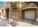 View of home featuring a stucco facade, well-maintained landscaping, covered entry and attached garage at 10332 Perfect Parsley St, Las Vegas, NV 89183