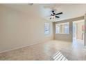 Open-concept living room with neutral tile flooring, ceiling fan, and great natural light at 2731 Heathrow St, Las Vegas, NV 89135