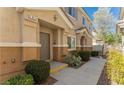 Townhome entry with walkway, landscaping, and two-car garage at 10111 Aspen Rose St # 101, Las Vegas, NV 89183