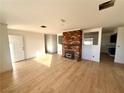 Bright living room with wood floors and brick fireplace at 1720 W Bell Vista Ave, Pahrump, NV 89060