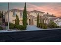 Two-story house with stone accents and a landscaped yard at sunset at 866 La Sconsa Dr, Las Vegas, NV 89138