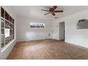 Open living room featuring tiled floors, white walls, a ceiling fan, and bright natural lighting at 1925 Franklin Ave, Las Vegas, NV 89104