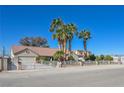 A well-maintained house featuring mature palm trees, a gated entrance, and a neutral color palette at 485 Sari Dr, Las Vegas, NV 89110