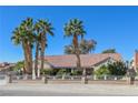 Charming single-story home featuring mature palm trees, a tile roof, and a secure gated entrance at 485 Sari Dr, Las Vegas, NV 89110