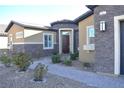 Close-up of home's entry featuring stone facade, complemented by a well-maintained garden at 7047 Noble Flair Ct, Las Vegas, NV 89131