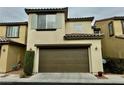 Attached garage with brown door and light colored house at 11416 Belmont Lake Dr # 102, Las Vegas, NV 89135